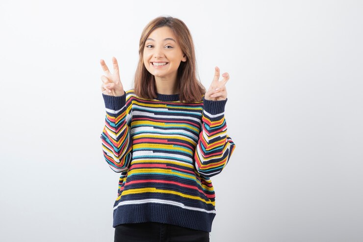 Foto grátis modelo de mulher bonita positiva em pé e mostrando sinal de vitória.