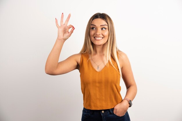 Modelo de mulher jovem mostrando gesto ok e posando.