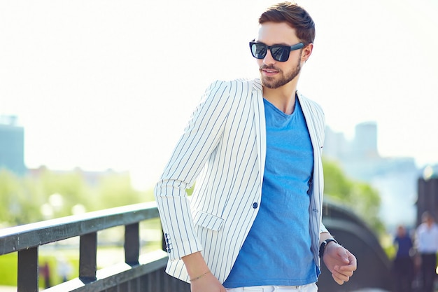 Modelo elegante jovem feliz confiante empresário elegante no estilo de vida de pano hipster terno na rua