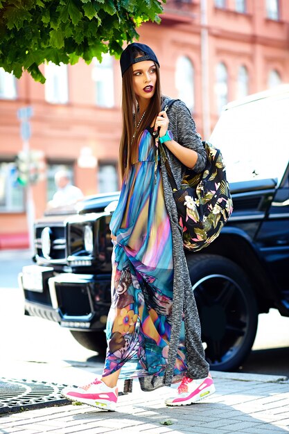 modelo elegante mulher jovem e bonita morena em roupas casuais coloridas de hipster de verão posando na rua