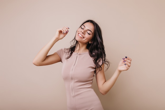 Modelo europeu de ótimo humor está dançando relaxado. menina com roupa da moda curtindo música e sorrindo