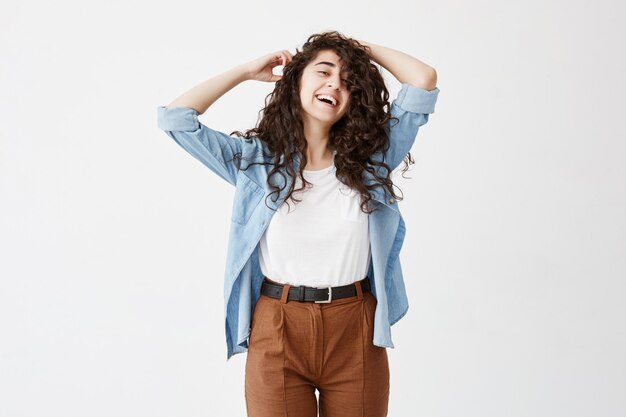 Modelo feminino emocional bonito, vestindo longos cabelos ondulados soltos tem um sorriso largo agradável e encantador, sonha com férias com o namorado. Felicidade e alegria