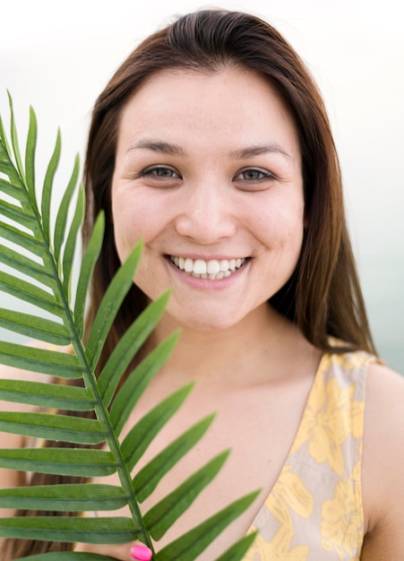 Modelo feminino jovem asiático e folha tropical