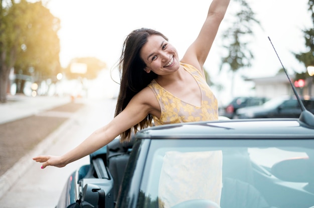 Modelo feminino jovem asiático, montando um carro