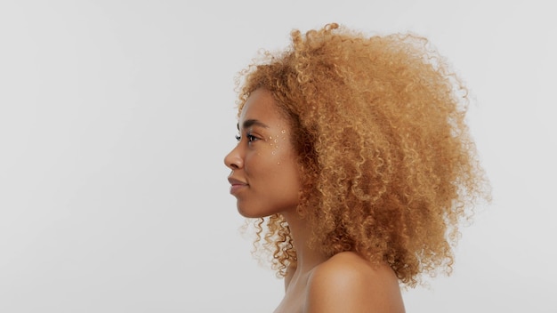 Modelo loiro preto de raça mista com cabelo encaracolado no cabelo loiro afro branco