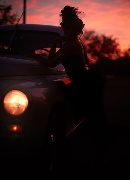 Foto grátis modelo loiro sexy moda linda com maquiagem brilhante e penteado encaracolado em estilo retro, sentado no carro velho