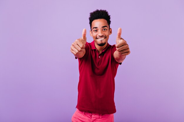 Modelo masculino confiante posando com um sorriso alegre. Homem bonito africano desfrutando.