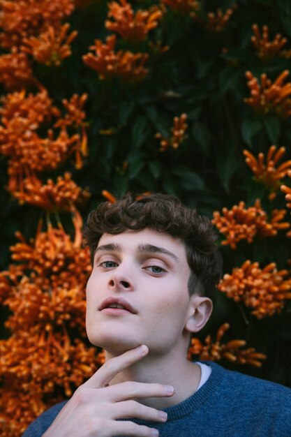 Modelo masculino jovem ao lado de flores