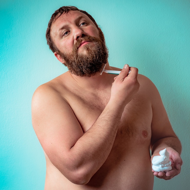 Foto grátis modelo masculino nu raspando a própria barba