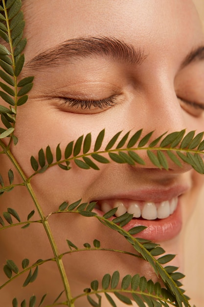Foto grátis modelo sorridente de close-up posando com a planta