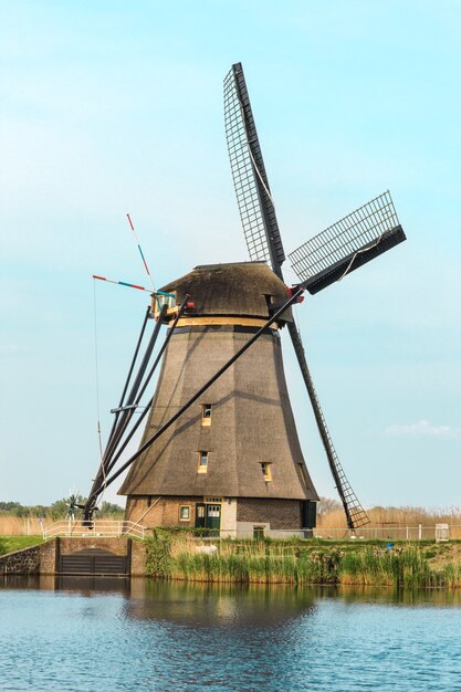 Moinhos de vento holandeses tradicionais com grama verde em primeiro plano, Holanda