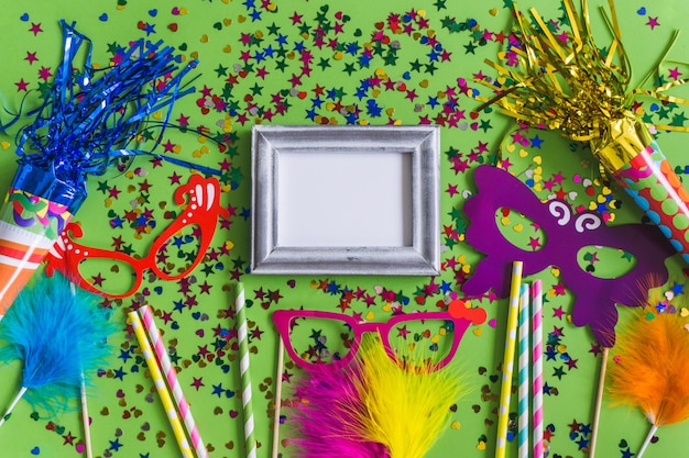 Foto grátis moldura cinza com confetes, vidros coloridos e paus visto de cima