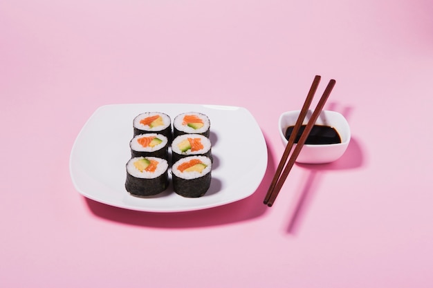 Molho de soja e pauzinhos perto de sushi saboroso