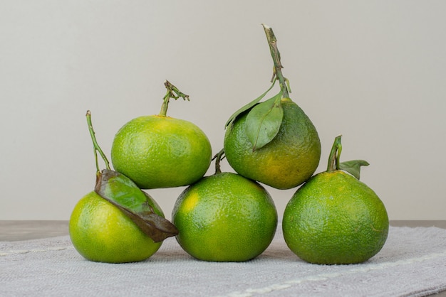 Molho de tangerinas frescas na toalha de mesa cinza