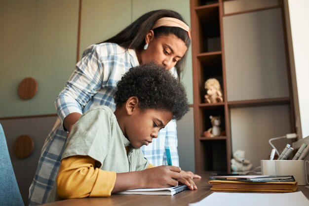 Momento médio, mãe e filho fazendo lição de casa