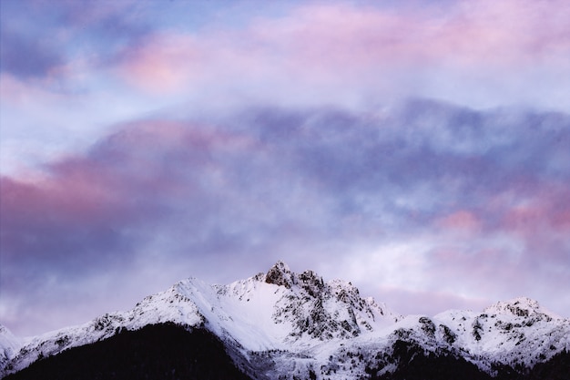 Montanha coberta de neve sob céu nublado