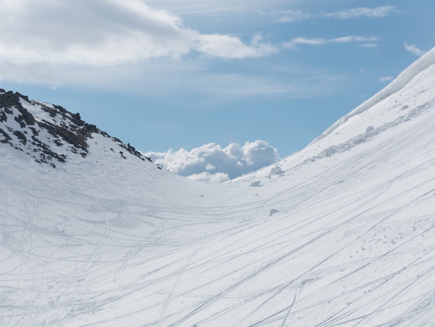 Montanhas cobertas de neve e vestígios de céu e céu brilhante