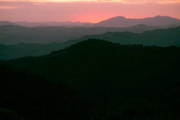 Montanhas em preto com céu rosa