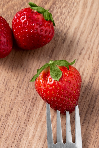 Foto grátis morangos deliciosos de alto ângulo na mesa