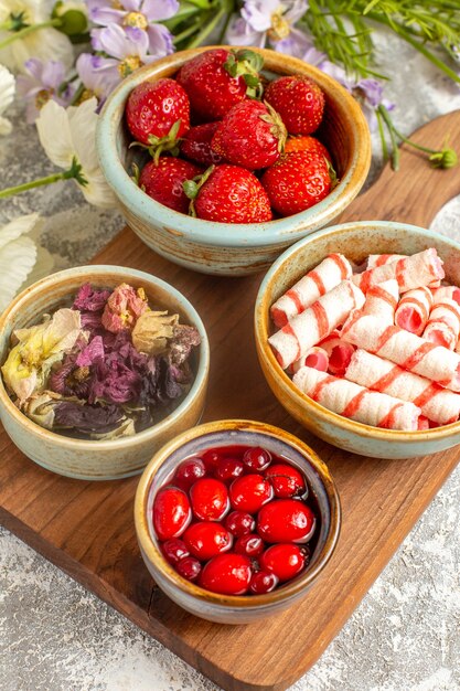 Morangos frescos vermelhos com flores na superfície branca de frutas vermelhas doces