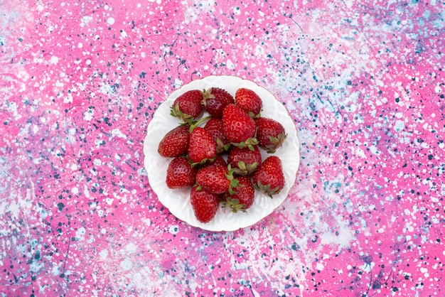 Foto grátis morangos frescos vermelhos frescos dentro de um prato branco na cor de frutas frescas de baga de fundo roxo