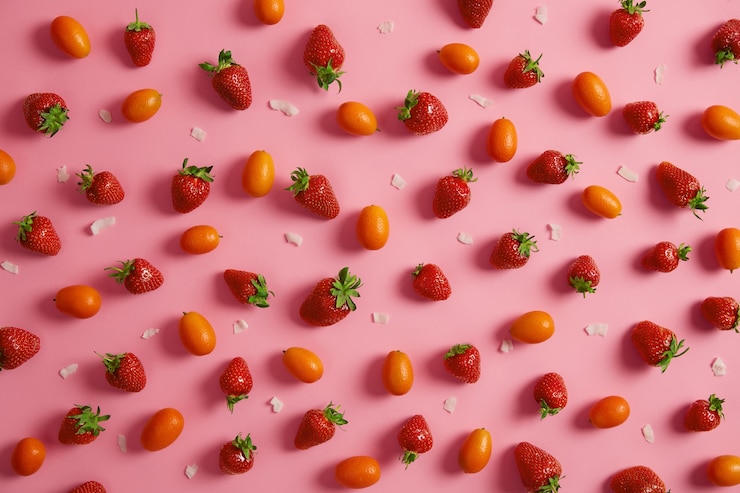 Foto grátis morangos maduros e apetitosos, cumquat de laranja fresco e flocos de coco branco isolados na parede rosa. frutas deliciosas para sua alimentação. comer limpo, lanche gostoso, conceito de horário de verão. vista de cima