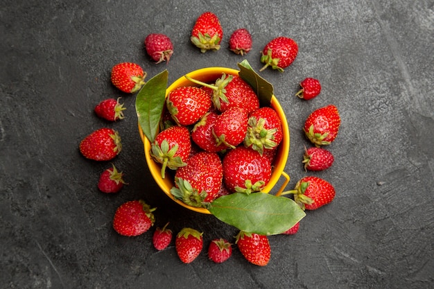 Morangos vermelhos frescos, de cima, alinhados com frutos silvestres de cor escura.