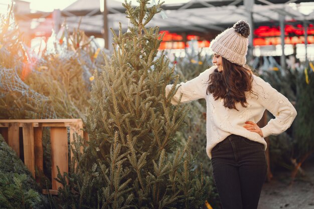 Morena bonita em uma camisola branca com árvore de Natal