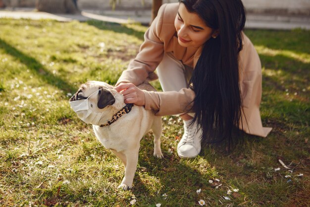 Morena em uma máscara caminha com pug