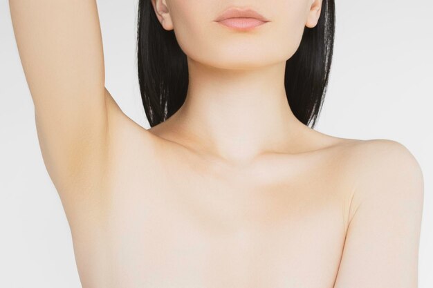 Morena magra com pele clara mostra axilas limpas após procedimento de depilação