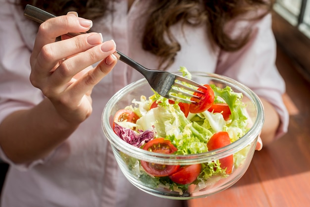 Morena mulher comendo uma salada