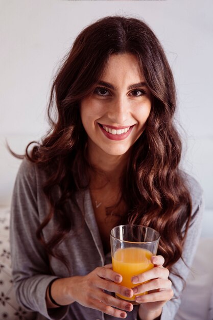 Foto grátis morena sorridente com suco