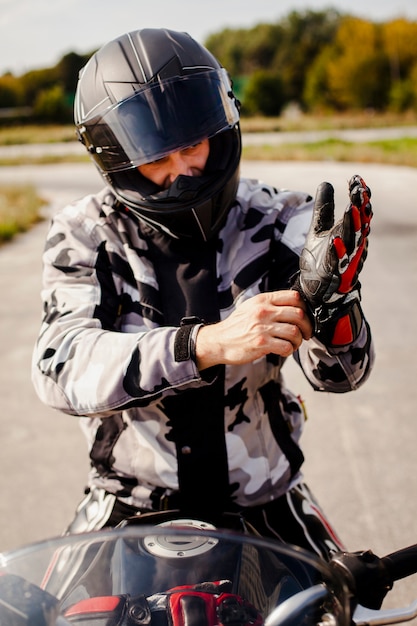 Motociclista cuidadosa, colocando o equipamento