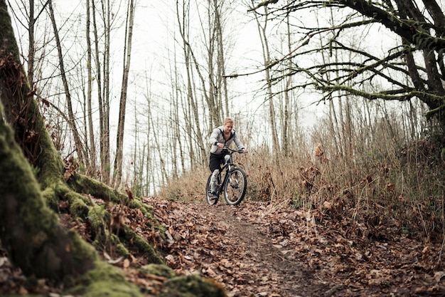 Motociclista de montanha, andar de bicicleta na trilha de floresta no outono