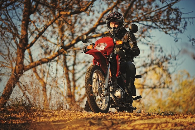 Foto grátis motociclista fica ao pôr do sol com ele moto enduro