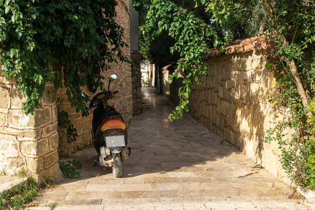 Motoneta estacionada em uma rua histórica estreita em uma cidade mediterrânea Foto Premium