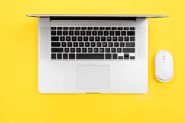Mouse de laptop e computador em plano de fundo amarelo