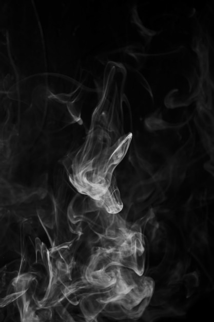 Movimento de fumaça sobre fundo preto, com espaço de cópia para escrever o texto