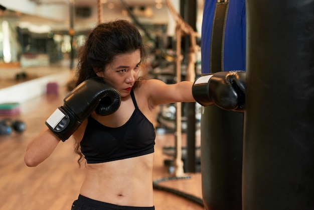 Muay thai boxer fêmea treinando com bola de perfuração