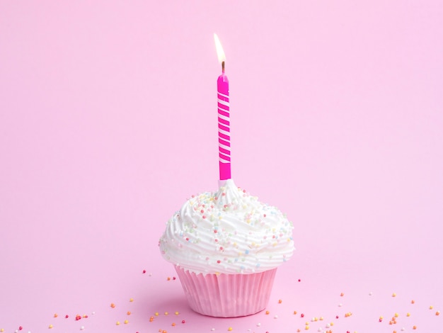 Muffin de aniversário delicioso com vela rosa