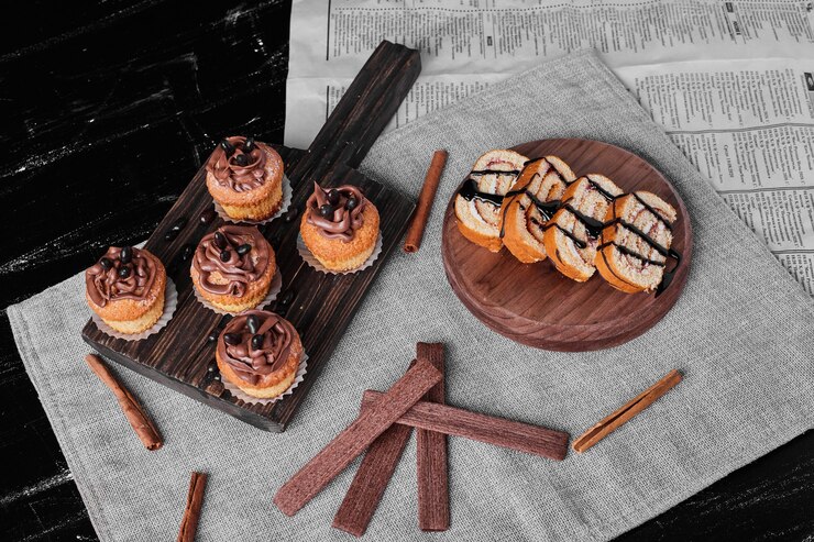 Foto grátis muffins com creme de cacau em uma placa de madeira com rodelas de bolo.