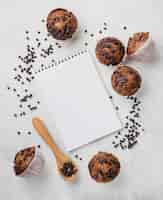 Foto grátis muffins de chocolate e bloco de notas