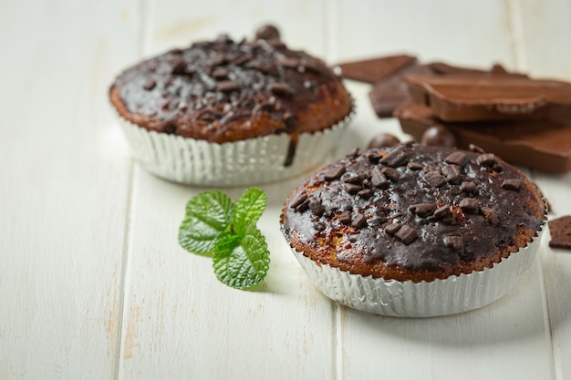 Muffins de chocolate na superfície de madeira branca. Conceito do Dia Mundial do Chocolate
