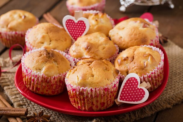 Muffins de frutas com noz-moscada e pimenta da Jamaica em uma cesta de vime sobre uma mesa de madeira