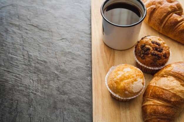 Muffins e café na placa de madeira