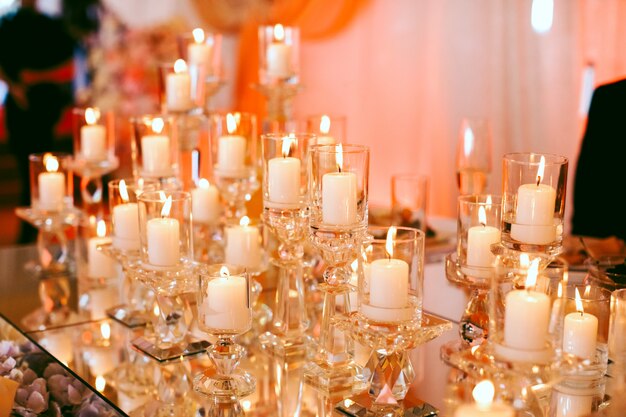 Muitas velas brancas acesas em cima da mesa