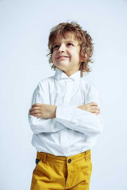 Muito jovem com roupas casuais na parede branca do estúdio