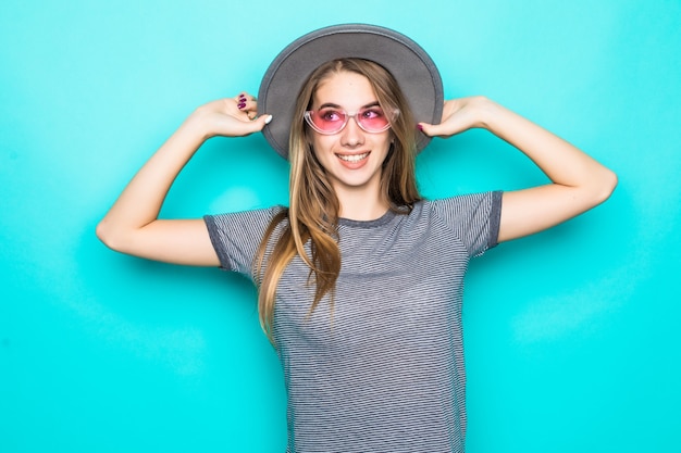 Muito jovem modelo na moda camiseta, chapéu e óculos transparentes isolados sobre fundo verde