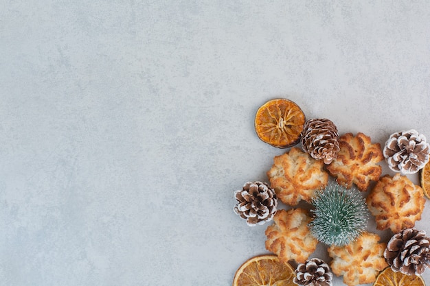 Muitos biscoitos frescos deliciosos com pequenas pinhas e laranjas secas.