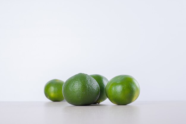 Muitos de tangerina verde na superfície de mármore.